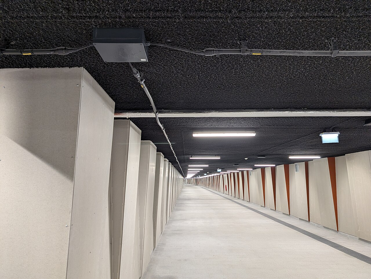 Kabel promieniujący zamontowany pod sufitem tunelu dla pieszych w Krakowie